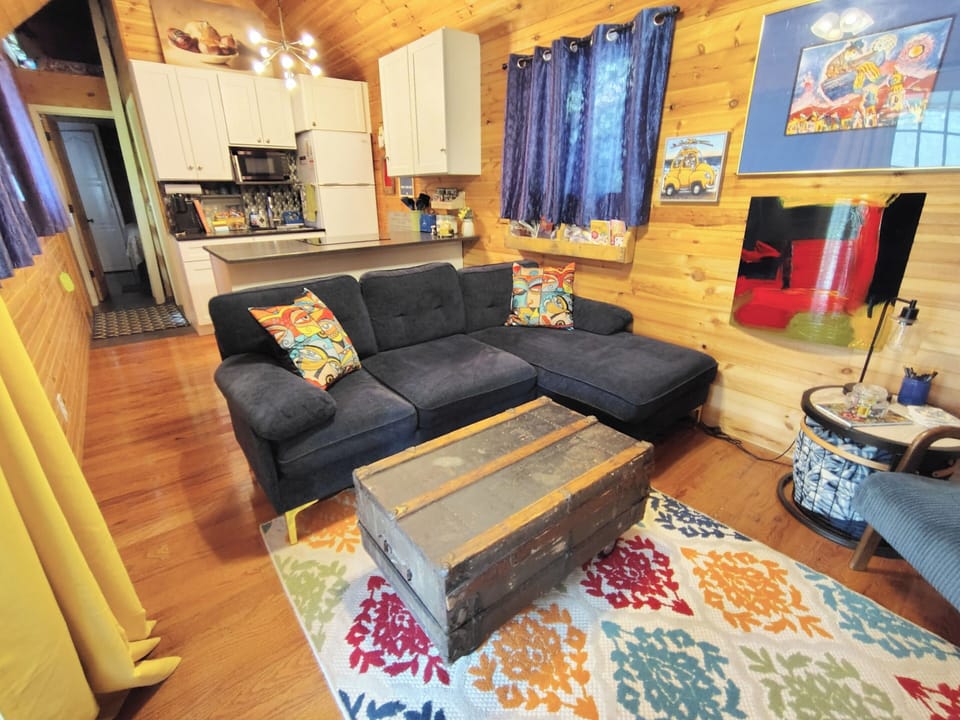 open concept-  kitchen visible, comfy couch.