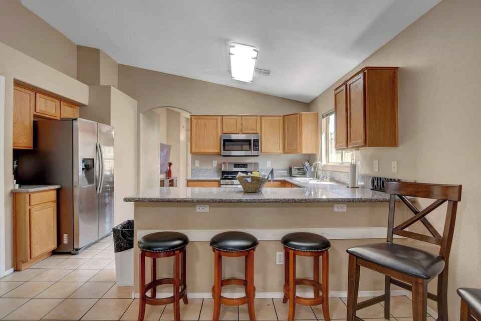 Spacious kitchen with granite bar, 4 stools & stainless appliances