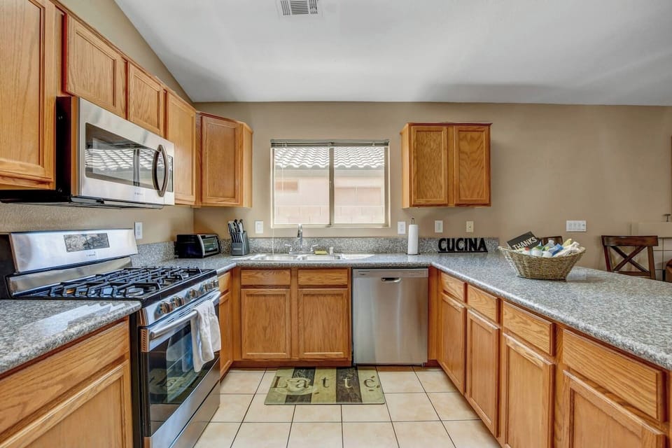 Bright U-shaped kitchen with stainless appliances and breakfast bar