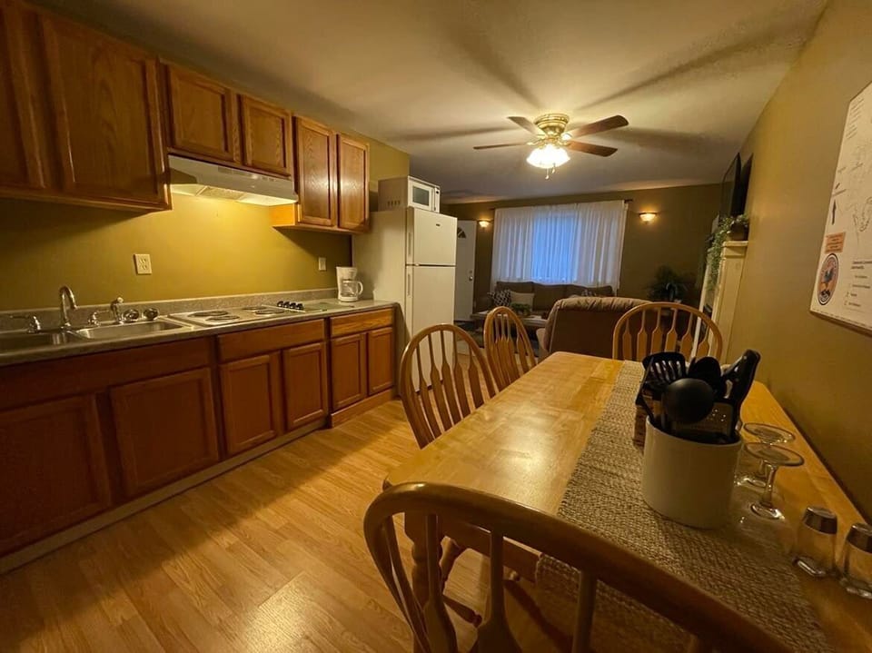 Kitchen offers stove & full size refrigerator, dinning table, pots, pans, dishes