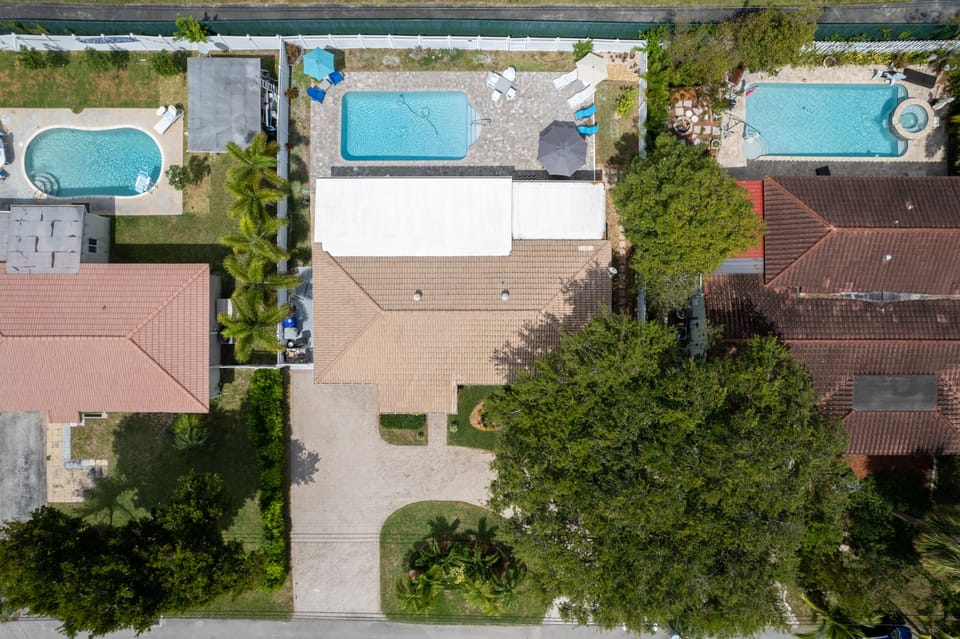 Large pool and patio with school behind creating a quiet family setting.