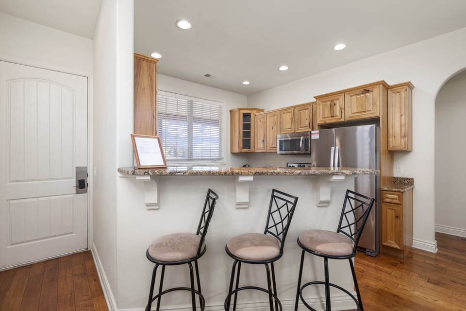 Kitchen opens to bar seating and dining area for a spacious feel 