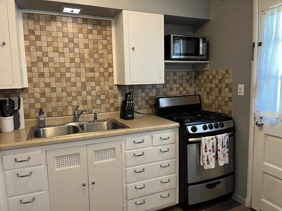 Kitchen w/essentials, microwave, stove, oven, refrigerator, freezer, coffee machine