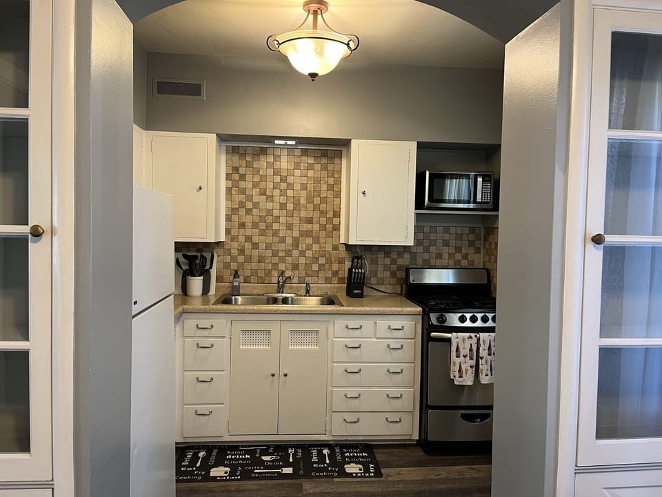 Kitchen w/essentials, microwave, stove, oven, refrigerator, freezer, coffee machine