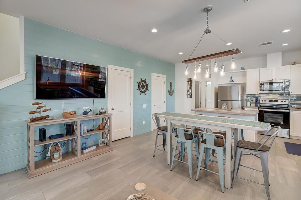 Relax in your coastal-themed open kitchen and dining space, featuring modern appliances, nautical décor, and a stylish island perfect for morning coffee.