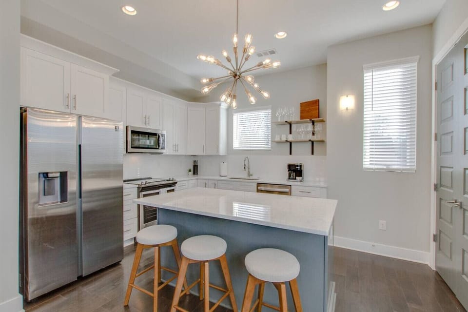 Gourmet kitchen with a quartz island, bar seating, and chandelier lighting
