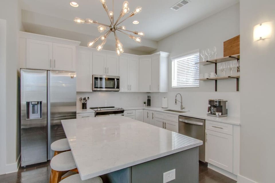 Bright kitchen featuring white cabinetry, an island, and modern fixtures