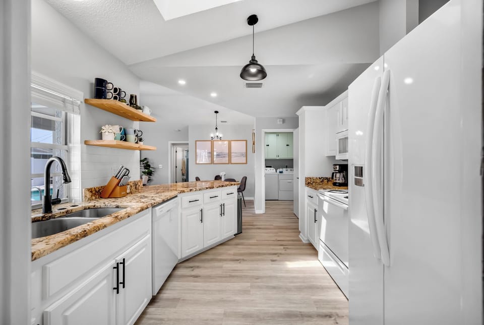 A galley kitchen with granite counters and open shelves that keeps things simple