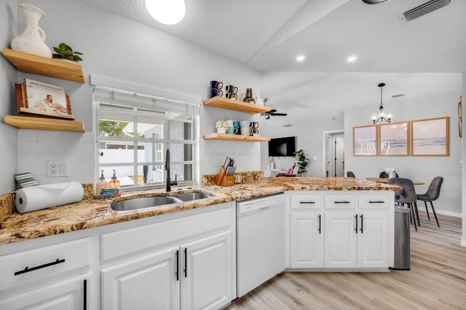 Subway tile and open mug shelves with the whole dining and living area ahead