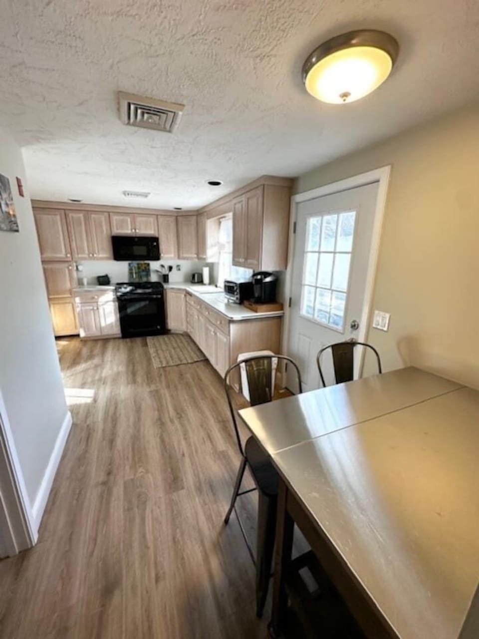 Fully furnished Kitchen complete with refrigerator, freezer, microwave, oven, coffee maker, and seating for two