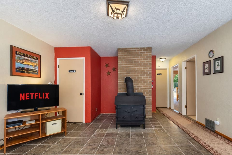 Cozy up by your wood-burning fireplace while streaming Netflix on the large TV in this welcoming living space.