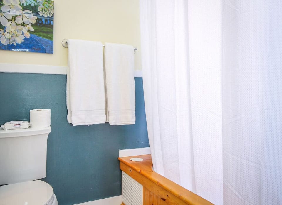 Stylish bathroom with pedestal sink and built-in claw-foot tub/shower combo.