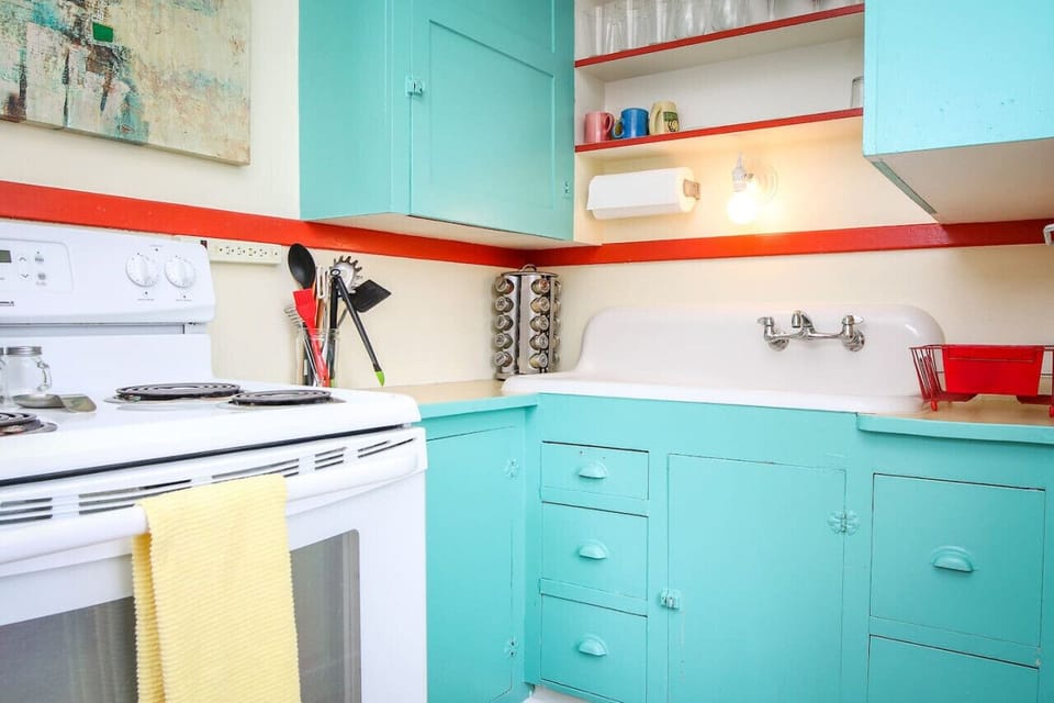 Darling kitchen with electric stove, microwave, Keurig, and an option to purchase wine.