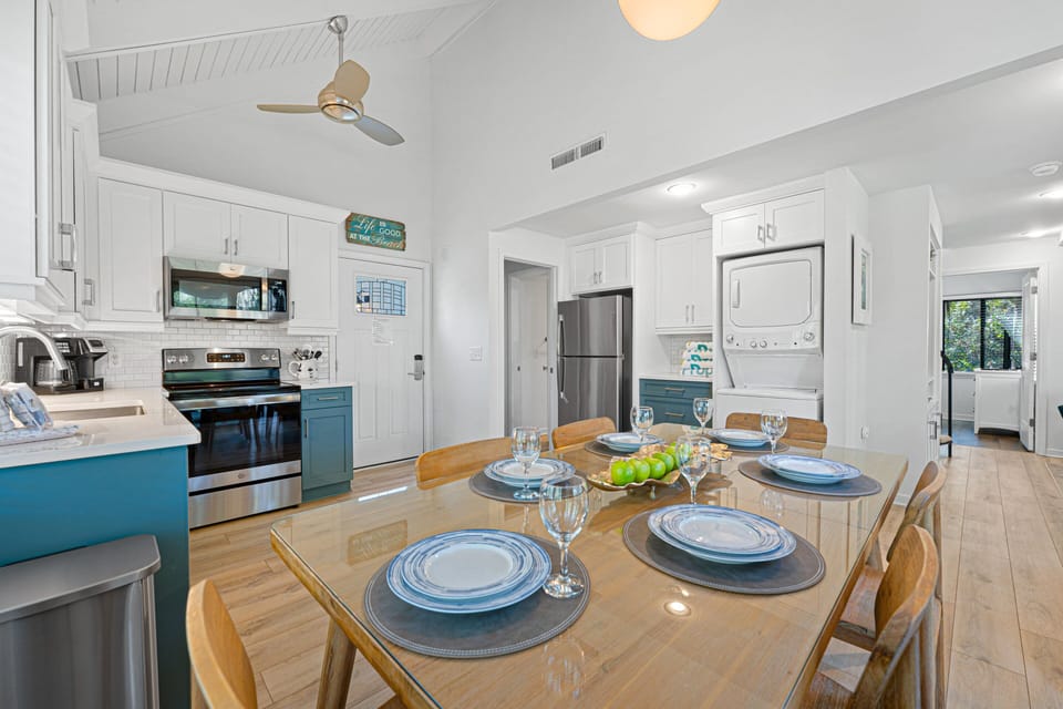 This light-filled dining and kitchen space offers an easy, open layout with vaulted ceilings and crisp white finishes.
