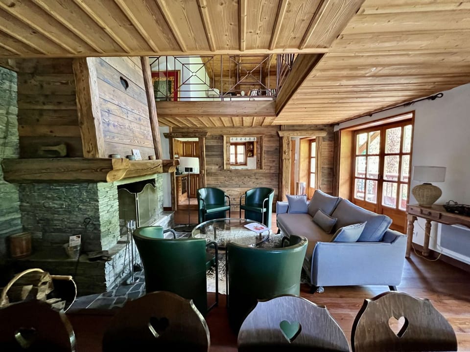 Living room, dining room, fireplace, long balcony with mountain views