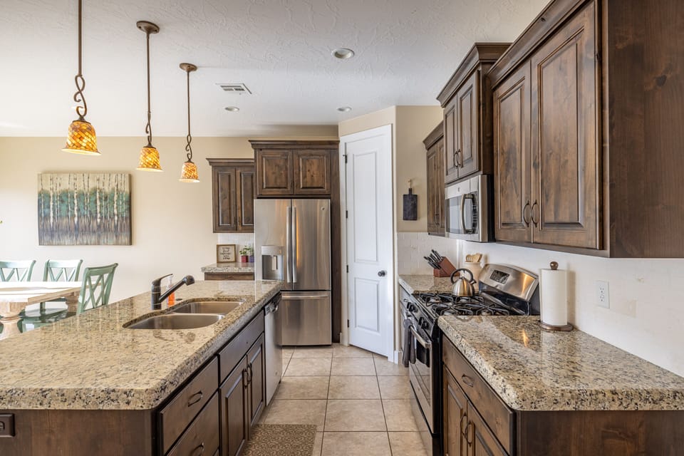 Kitchen Side View - Side view of kitchen showing off the beautiful counter tops and stainless-steel appliances.