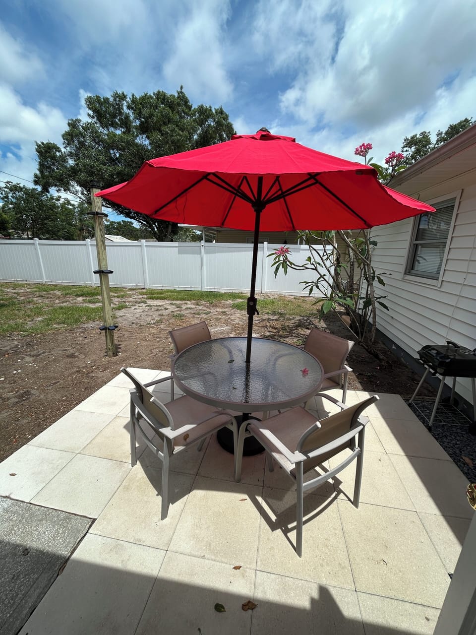 Fenced back patio with grill.