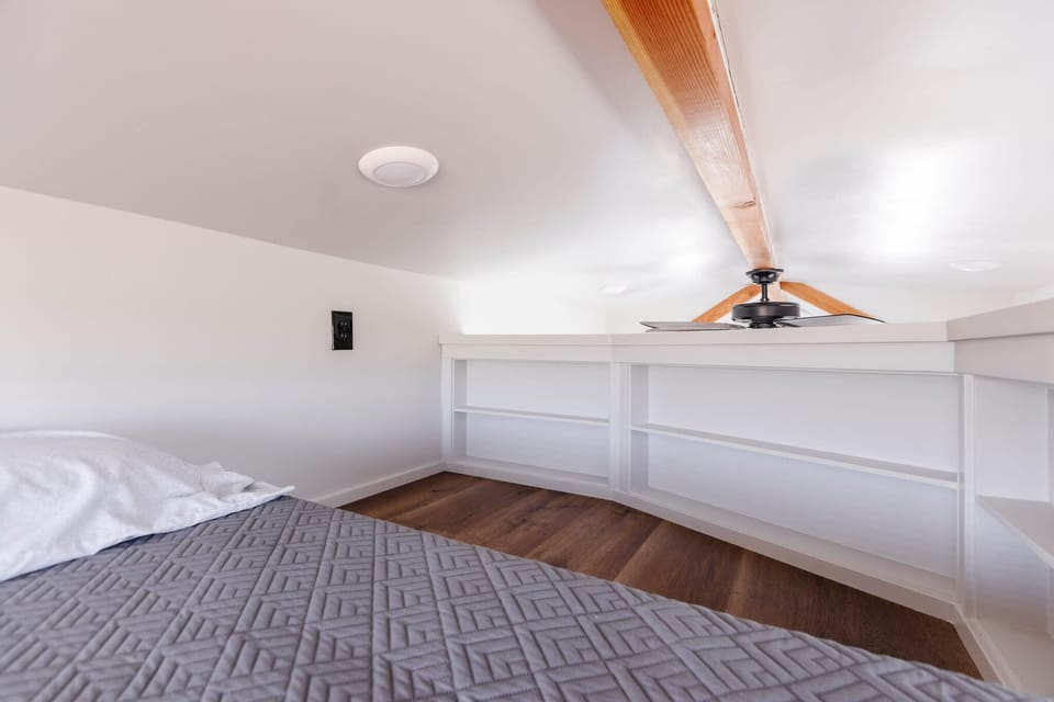 This bright loft bedroom offers a comfortable queen bed, vaulted ceilings, skylight views, and extra space to relax after a day exploring Zion National Park and Southern Utah adventures.