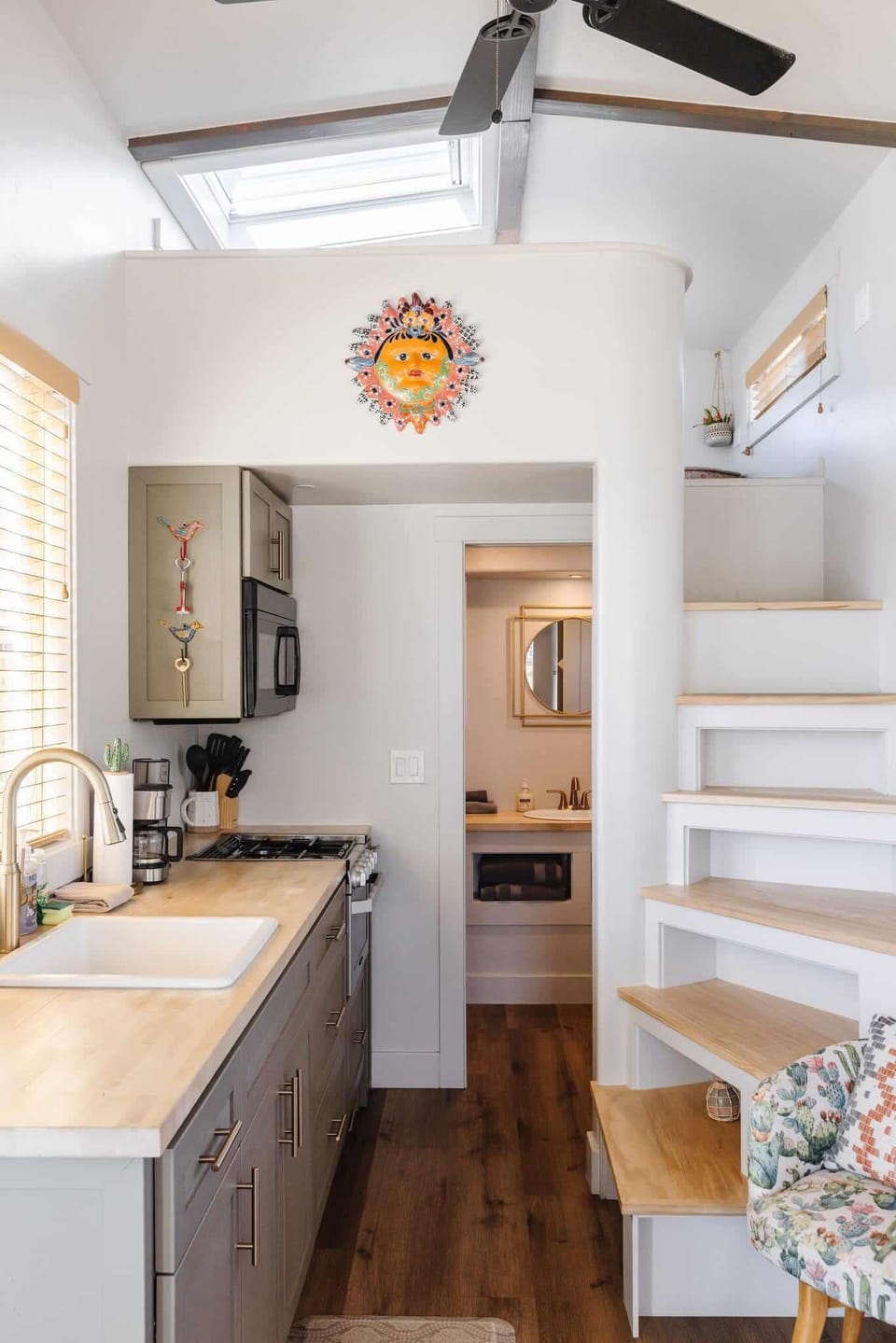 Bright kitchen view looking toward the loft stairs, highlighting the smart use of space in this thoughtfully designed tiny home.