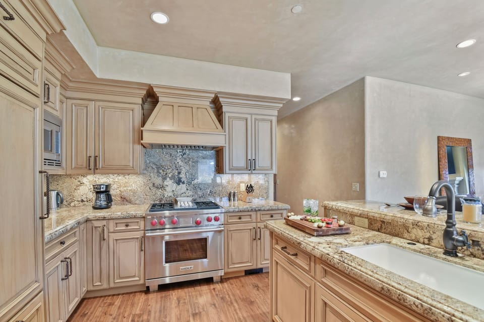 Create memorable meals in this chef-inspired kitchen featuring granite countertops, custom wood cabinetry, and premium appliances designed for effortless entertaining.