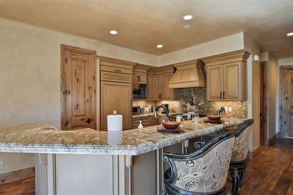 Premium appliances, granite countertops, and custom cabinetry provide everything needed for preparing memorable meals.