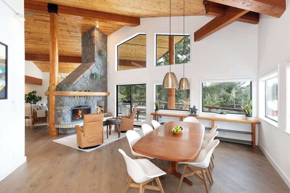 - Spacious dining area with wooden table and seating for group meals or gatherings  
- Surrounded by windows showcasing panoramic mountain and forest scenery  
- Ideal setting for memorable dinners in a cozy alpine-inspired environment 