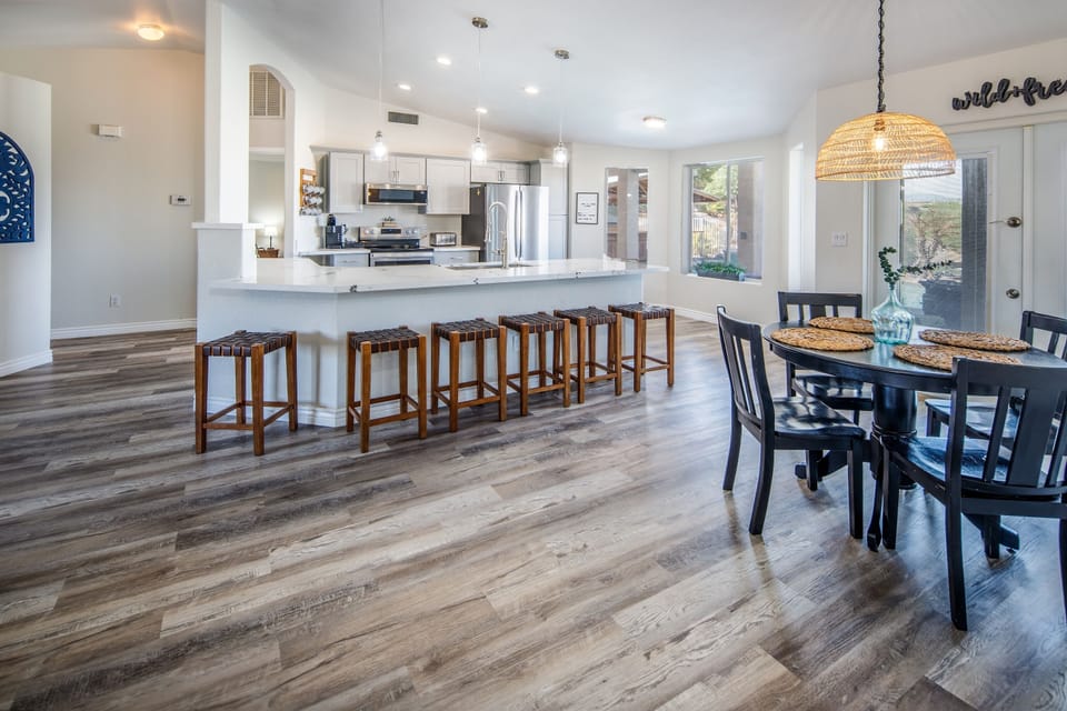 Six barstools line the large granite island along with a table that seats four 