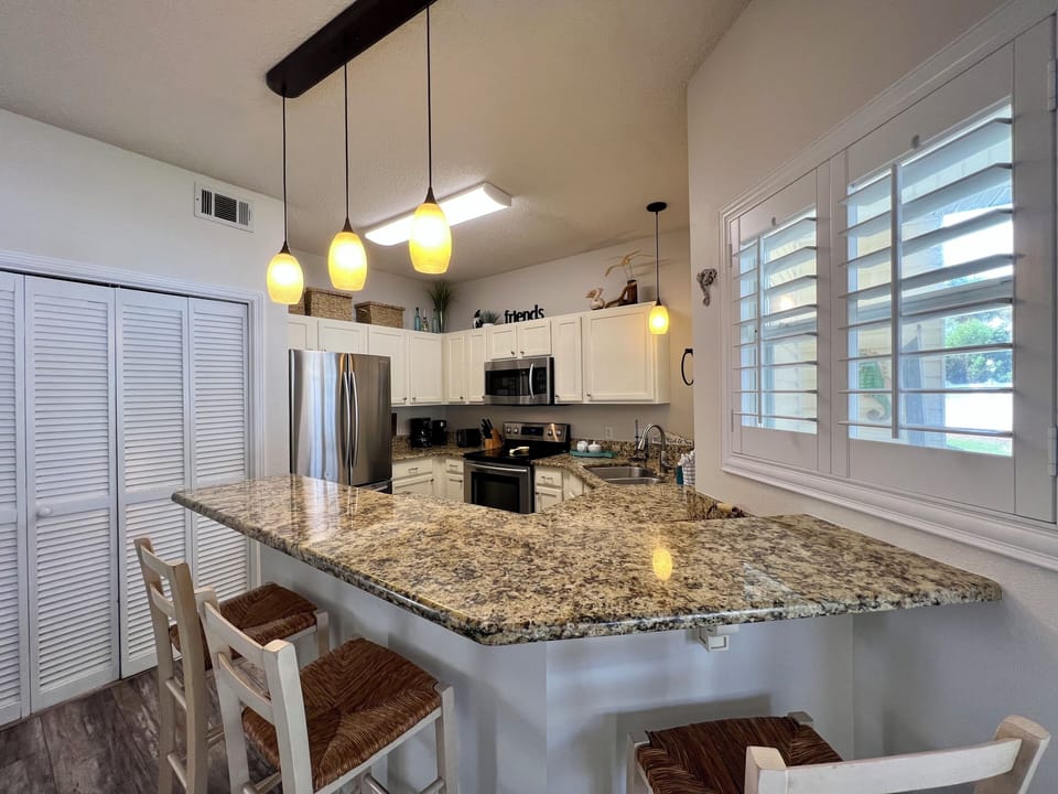 Your beautiful kitchen offers granite countertops, stainless appliances, and pendant lighting, perfect for preparing meals with style and comfort.