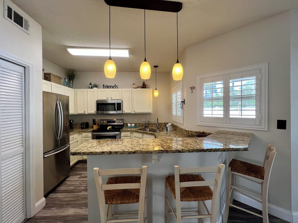 Your spacious kitchen features granite countertops, stainless appliances, and a breakfast bar where you can start mornings with coffee and conversation.