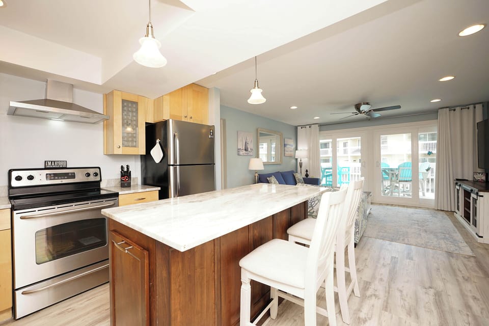 Your open-concept kitchen flows seamlessly into the living area, where marble countertops and modern appliances invite culinary adventures.