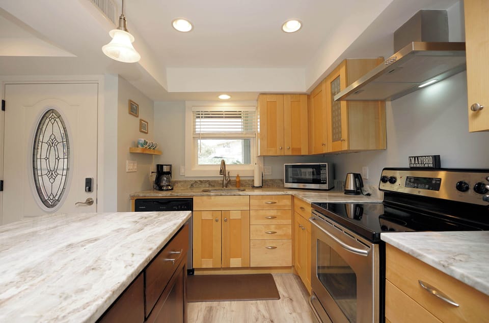 Your fully equipped kitchen awaits with granite counters, stainless appliances, and warm wood cabinetry for memorable home-cooked meals.