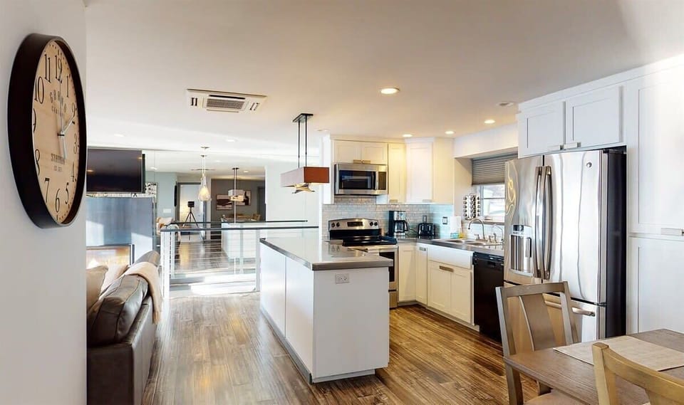 Your spacious kitchen features sleek white cabinets, stainless steel appliances, and a convenient island for cooking and gathering with loved ones.
