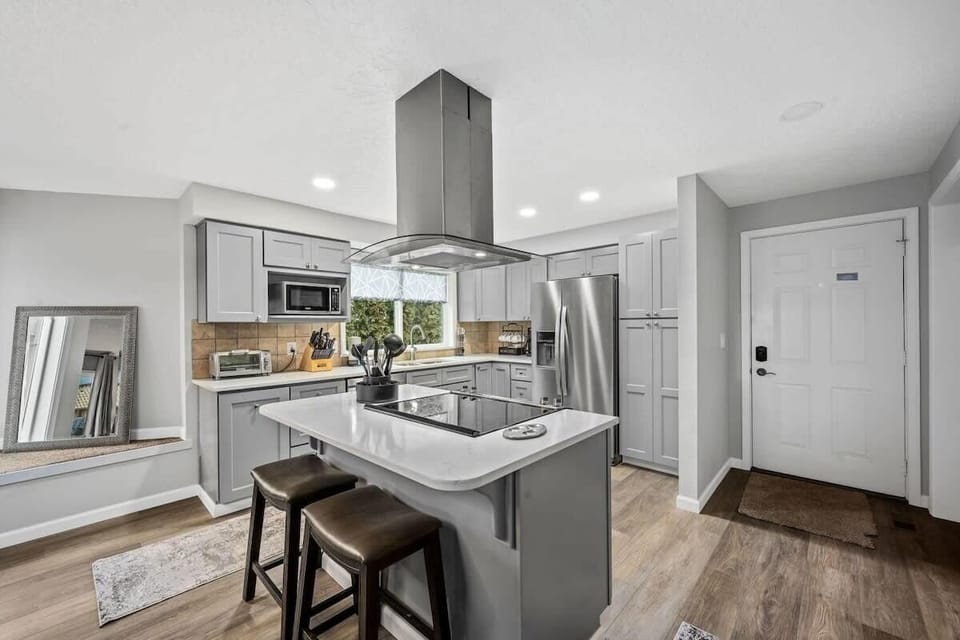 You'll love cooking in this sleek modern kitchen with stainless steel appliances, quartz countertops, and a convenient breakfast bar for casual dining.