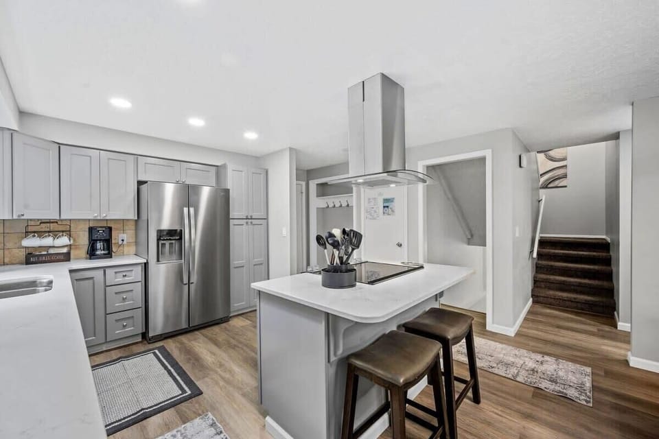 Your modern kitchen awaits with stainless steel appliances, sleek island seating, and everything you need to create delicious meals during your stay.