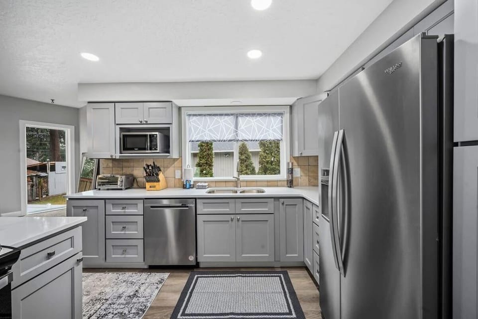 Cook your favorite meals in this modern kitchen featuring stainless steel appliances, ample counter space, and bright natural light streaming through windows.