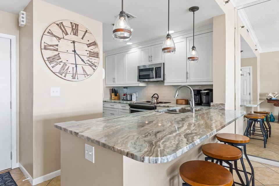 Fully equipped kitchen with stainless steel, two coffee makers, blender, and toaster.