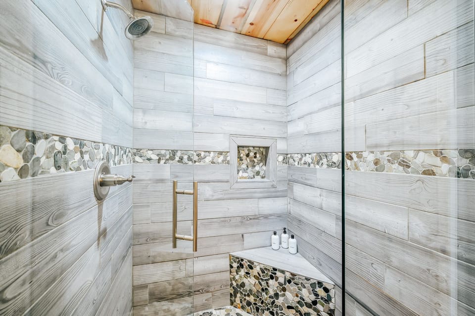Wooden style wall shower area, glass door, shower, toilet bowl