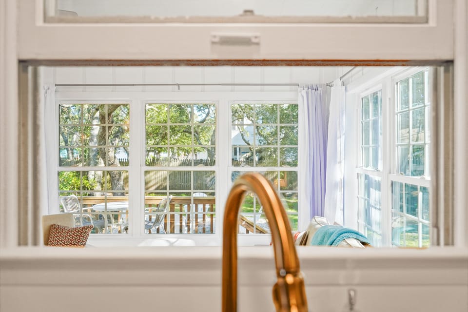 The window from the kitchen to the sun room keeps everyone together.