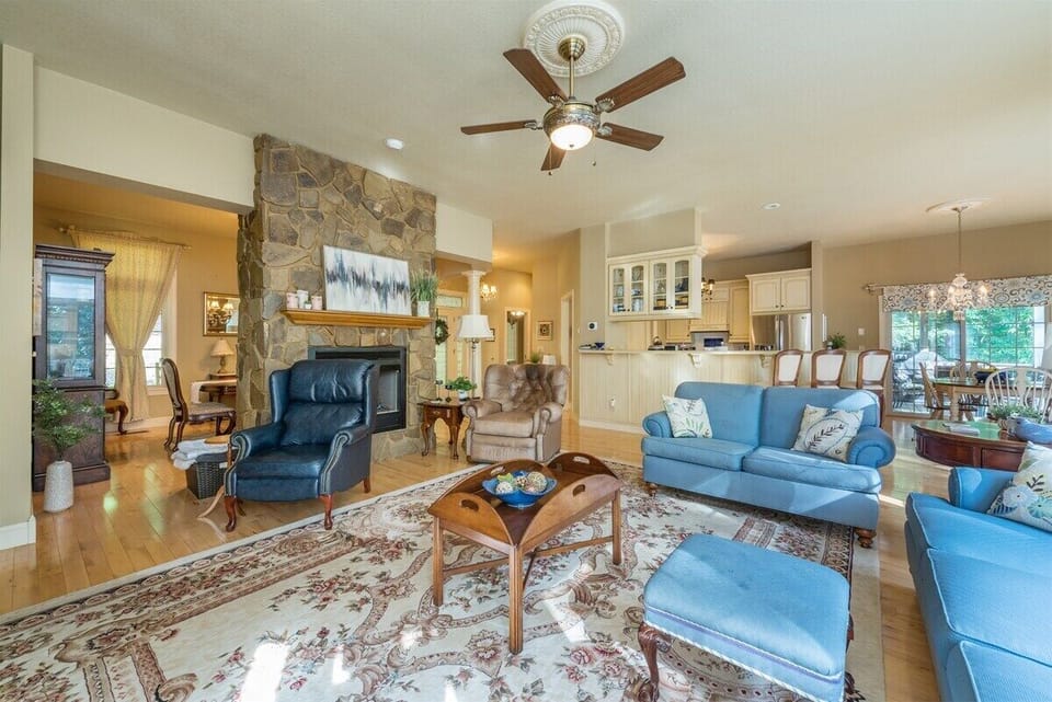 open living room with a fireplace, ceiling fan, and tv!