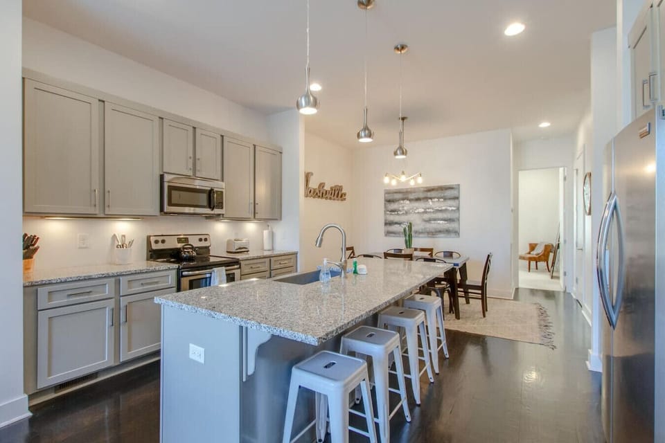 The spacious kitchen features stainless appliances, a granite island, and pendant lighting for a polished feel.