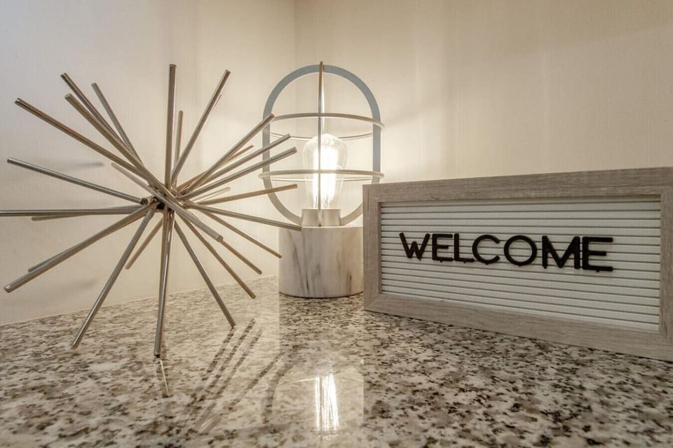A golden Welcome sign and starburst sculpture greet you at the entry with a warm, curated touch.
