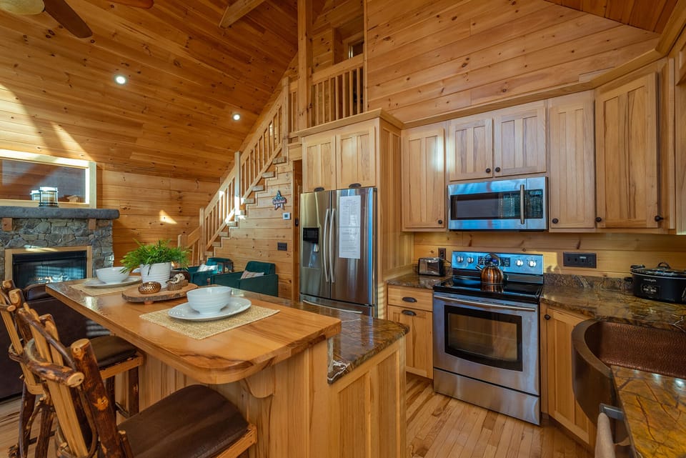 Kitchen area with larger island, electric stove and copper sink