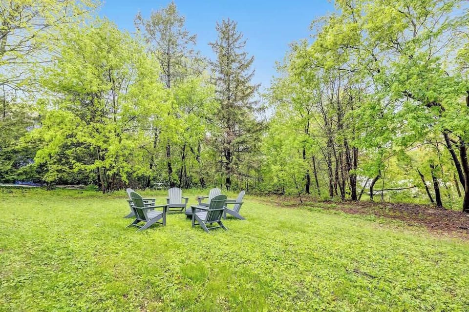Back yard fire pit with 6 Adirondack chairs.