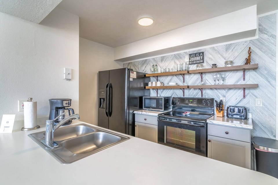 Fully equipped kitchen with electric stove and oven, drip coffee maker, refrigerator, microwave, dishwasher and more!