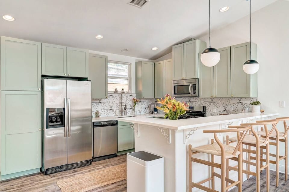 Fully equipped and well-stocked updated kitchen with high chairs.