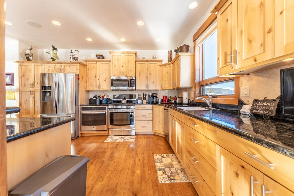 You'll love preparing meals in this spacious kitchen with warm wood cabinets, granite counters, and stainless steel appliances.