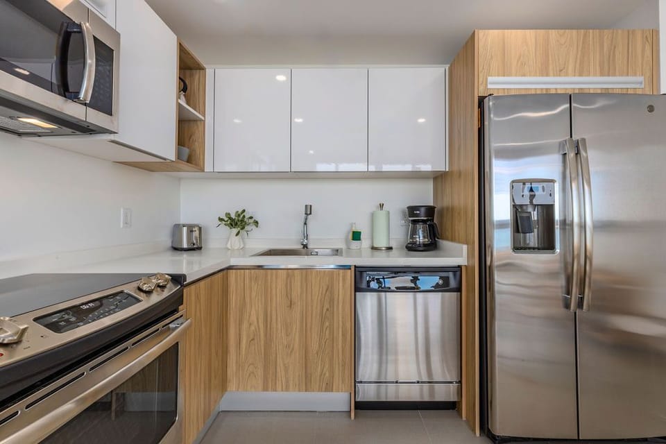 Your fully-equipped kitchen features sleek stainless steel appliances, modern wood cabinetry, and ample counter space—perfect for whipping up meals during your stay.