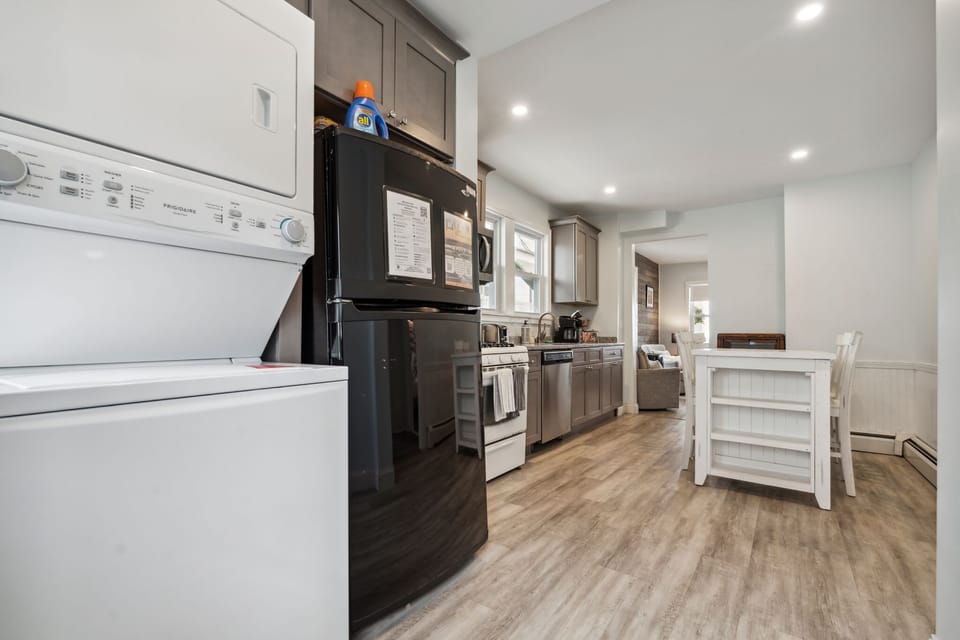 Fully equipped kitchen with updated appliances, washer/dryer unit, and 4-person dining table
