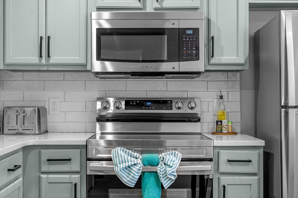 Well-equipped kitchen w/ microwave, oven, and neatly styled finishes.