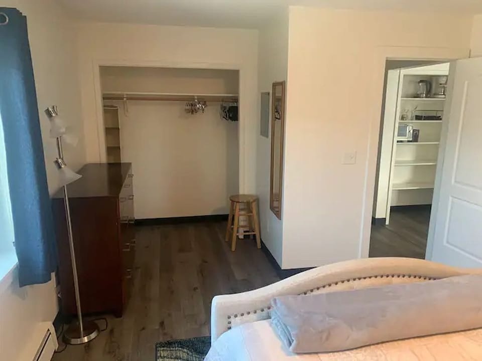 Full dresser and closet in bedroom with extra bedding for pull out couch bed